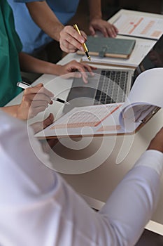 Medical Team Meeting Around Table In Modern Hospital