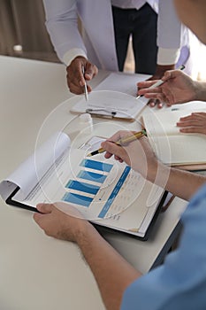 Medical Team Meeting Around Table In Modern Hospital