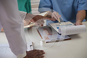 Medical Team Meeting Around Table In Modern Hospital