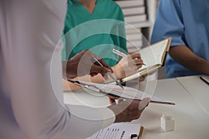 Medical Team Meeting Around Table In Modern Hospital