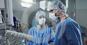 Medical team, people and doctor in operating room to talk, strategy and pointing at screen for surgery. Man, woman and