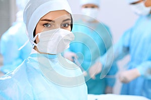 Medical team performing operation. Focus on female surgeon