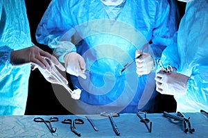 Medical team performing operation. Group of surgeon at work in operating theatre toned in blue