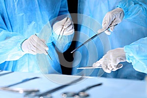 Medical team performing operation. Group of surgeon is working in operating theatre toned in blue