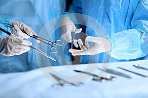 Medical team performing operation. Group of surgeon is working in operating theatre toned in blue