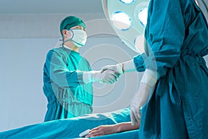 Medical team performing a surgical operation in operating room, Concentrated surgical team operating a patient