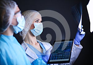 Medical team speaking of a X-ray in an operating room