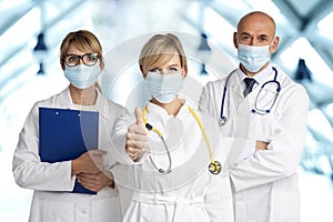 Medical team standing together on the hospital`s foyer and wearing face masks