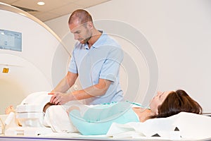 Medical technical assistant preparing scan of knee with MRI
