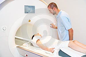 Medical technical assistant preparing scan of shoulder with MRI