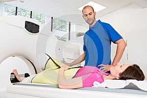 Medical technical assistant preparing scan of the spine with CT photo