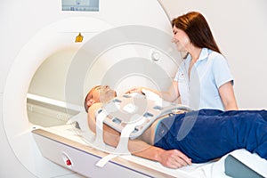 Medical technical assistant preparing scan of torso with MRI photo