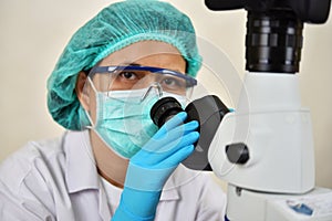 Medical technologist working with microscope photo