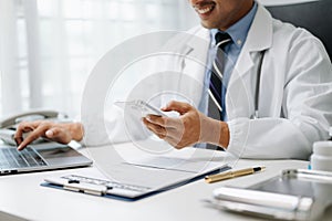 Medical technology concept. Doctor working with mobile phone and stethoscope in office