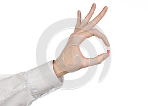 Medical theme: doctor's hand holding a red capsule for health on a white background isolated