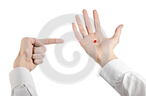 Medical theme: doctor's hand holding a red capsule for health on a white background isolated