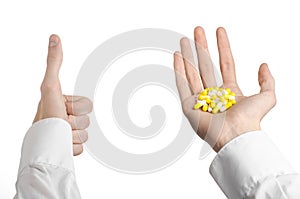 Medical theme: doctor's hand holding a yellow capsule for health on a white background isolated
