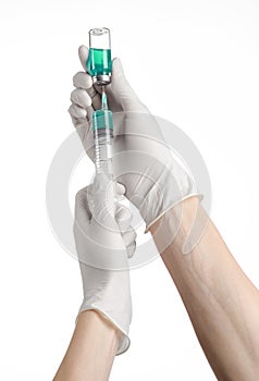 Medical theme: doctor's hand in a white glove holding a blue vial of liquid for injection isolated on white background