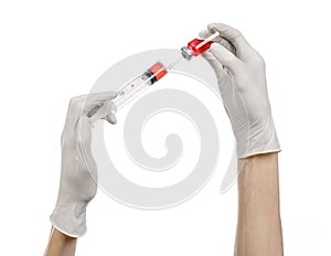 Medical theme: doctor's hand in a white glove holding a red vial of liquid for injection isolated on white background