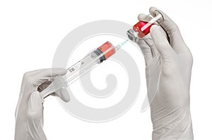 Medical theme: doctor's hand in a white glove holding a red vial of liquid for injection isolated on white background