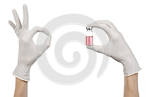 Medical theme: doctor's hand in a white glove holding a red vial of liquid for injection isolated on white background