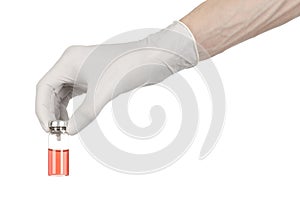 Medical theme: doctor's hand in a white glove holding a red vial of liquid for injection isolated on white background