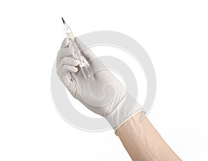 Medical theme: doctor's hand in white gloves holding a thermometer to measure the temperature of the patient on a white background