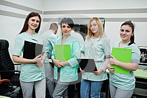 Medical theme.Observation room with a computer tomograph. The group of female doctors with clipboards meeting in the mri office at