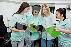 Medical theme.Observation room with a computer tomograph. The group of female doctors with clipboards meeting in the mri office at