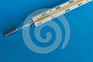 Medical thermometer on a blue background