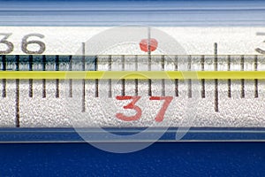 Medical thermometer closeup on blue background