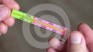 A medical thermometer in men`s hands close-up. Covid-19 and the epidemic of infection