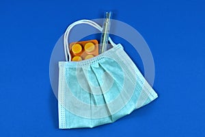 Medical thermometer and pills with a face mask in the shape of a bag
