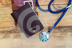 Medical tourism concept. Stethoscope with passport on wooden