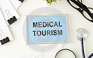 Medical Tourism, medical travel concept. Stethoscope, toy plane and passport on grey background.