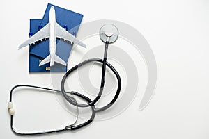 Medical Tourism, medical travel concept. Stethoscope, toy plane and passport on grey background.