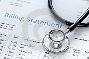 Medical treatmant billing statement with stethoscope on stone background photo