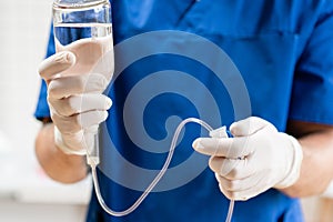 Doctor in blue uniform holding drip iv and infusion pump, . Intravenous fluid for seriously patient in the emergency photo