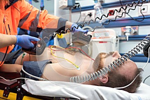 Medical urgency in the ambulance. Emergency doctor using defibrillator photo