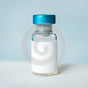 Medical vaccine vials or bottles on table top over blue background. blank vial template for label. empty white label on the bottle