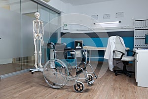 Medical wheelchair for invalid patient standing in empty doctor office