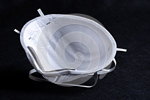 Medical white mask to protect covid-19 on a black background, quarantine protection against viruses, dust, flu