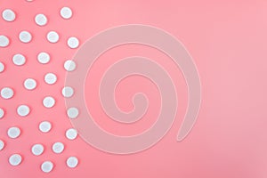 Medical white pills and pills on a pink background. The concept of healthcare, medical care. Copy space
