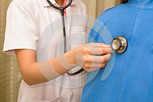 Medical woman listening to a woman's chest