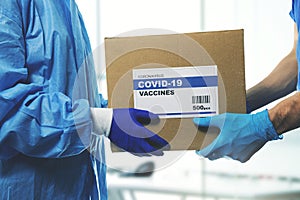 medical worker accepting delivery of covid-19 vaccines from deliveryman