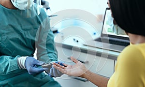 Medical worker checking glycemia test for diabetes to female patient during corona virus outbreak photo