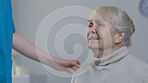 Medical worker comforting desperately crying elderly woman in nursing home