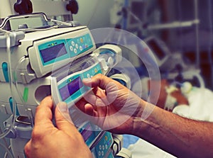 Medical worker configures equipment in ICU photo