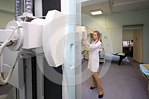 Medical worker controls x-ray equipment in
