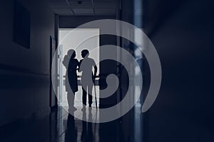 Medical worker is helping disabled lady cross hallway